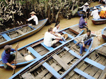 Wisatawan bersampan di anak Sungai Mekong.
